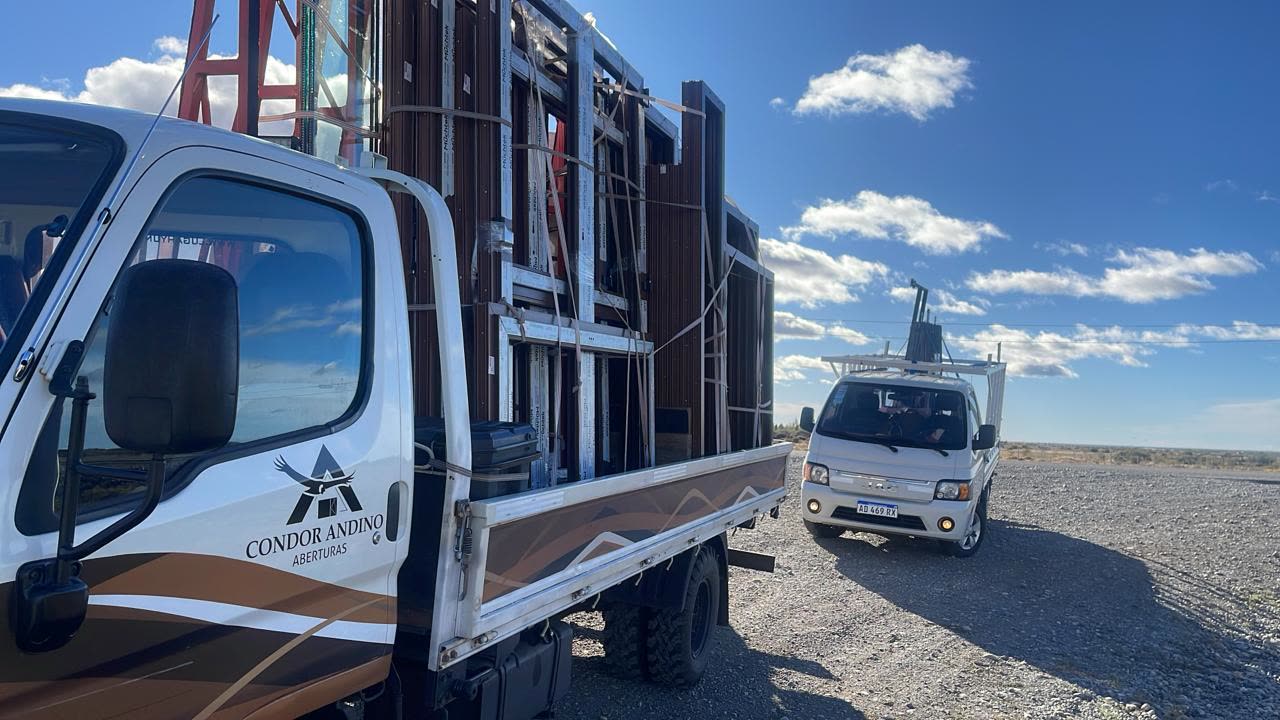 Camión de Cóndor Andino cargado con aberturas de PVC rumbo a la obra